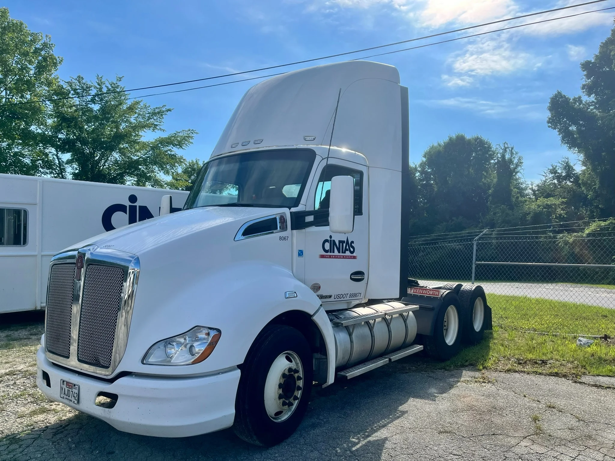 White commercial semi truck before a mobile exterior wash, with road grime on lower body and wheels